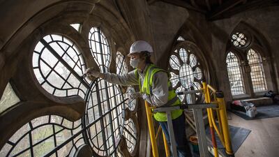 A conservator works on the framework of a window at Westminster Abbey in 2016