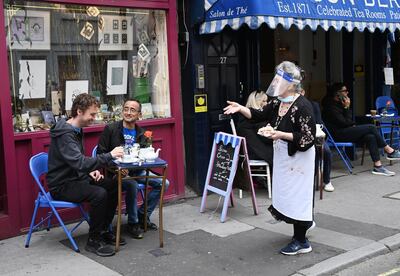 Customers at a tea room outside in Soho, London, UK, July 4, 2020. EPA