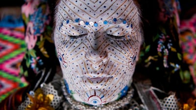 Sheqerie Buqaj lays on her back as she receives a traditional face painting by Aziza Sefitagic, while presenting the traditional wedding of Bosnian women from Zhupa region, during the "Etno Fest" festival in the village of Kukaj. AFP
