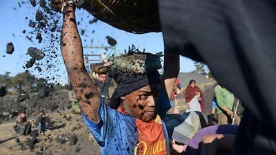 A teenage worker places a basket filled with coal on his head at a roadside coal depot in the Indian state of Meghalaya. Roberto Schmidt / AFP
