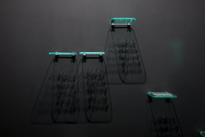 Traces, 2026, uses engraved glass, light and shadow to turn Al Haj’s inscriptions into shifting fragments of meaning. Victor Besa / The National