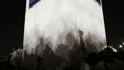 Muslim pilgrims sign their names on a white pillar, where Islam’s Prophet Mohammad is believed to have delivered his last sermon to tens of thousands of followers, on a rocky hill known as Mountain of Mercy, on the Plain of Arafat. Nariman El-Mofty / AP Photo