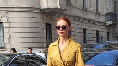 A belted mustard taffeta dress outside the Max Mara show