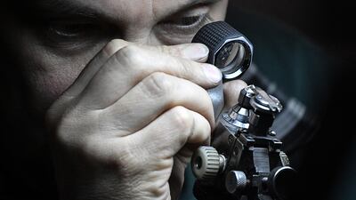 A diamond cutter inspects a diamond at the Alrosa Diamond Cutting Division in Moscow in 2019. AFP