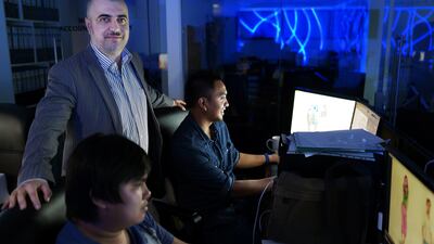 Ashraf Badrieh, left, managing director at Production House, with artists Jhay Ahr Aglato, right, and Jowell Gusi. Delores Johnson / The National