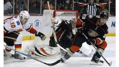 Francois Beauchemin, right, clears the puck to help Anaheim goalie Dan Ellis against Calgary. Alex Gallardo / Reuters