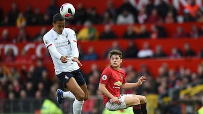 Liverpool defender Virgil van Dijk heads the ball as Manchester United's Daniel James chases. AFP