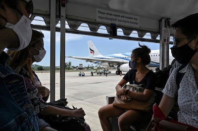 Passengers wearing face masks as a preventive measure against the coronavirus padnemic ride a shuttle to a Bangkok Airways domestic flights at Koh Samui airport. AFP