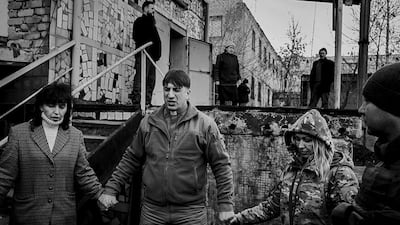 Oleg Tkachenko, 47, a chaplin from the Good News Church in Slavyansk, prays with soldiers and volunteers at a meeting in the front-line town of Mariinka. Photo by Alex Masi.