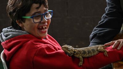 Gabriel smiles when seeing a lizard on him during a therapy session