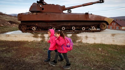 Kosovan-Albanian children walk near by a destroyed Serbian military tank in the village of Fushtica in Kosovo. EPA