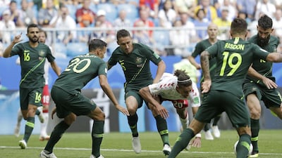 Denmark's Yussuf Yurary Poulsen, centre, goes down under a challenge by Australia's Mark Milligan, third left. Gregorio Borgia / AP Photo