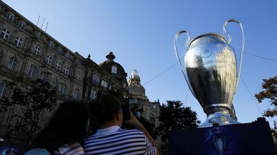 People take pictures of an inflatable model of the Champions League trophy in Porto's central Aliados square. Reuters