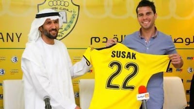 Hamad bin Lahej, left, the Al Wasl vice chairman, hands over a kit top to Milan Susak who wants to bring the championship form he has experienced elsewhere to Zabeel Stadium.