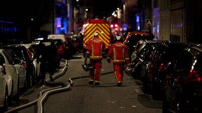 Firefighters and a police officer are seen near a building that caught fire in the 16th arrondissement in Paris, on February 5, 2019. AFP