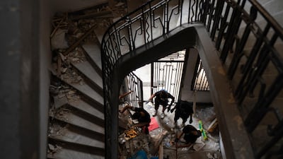 People remove debris of a damaged building at a neighboUrhood near the scene of Tuesday's explosion that hit the seaport of Beirut. AP