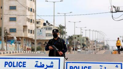 A policeman wearing protective gear as a precaution against the coronavirus guards a security checkpoint in Gaza City. AFP