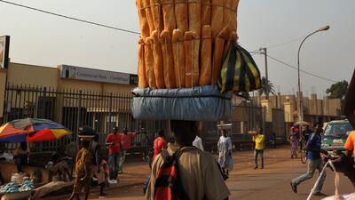 A seller carries baguettes on his head in a market at Bangui in the Central African Republic. AFP