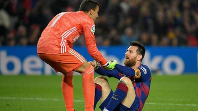 Valladolid's Spanish goalkeeper Jordi Masip helps Barcelona's Argentine forward Lionel Messi to stand up during the Spanish league football match between FC Barcelona and Real Valladolid FC at the Camp Nou stadium in Barcelona on October 29, 2019. / AFP / LLUIS GENE
