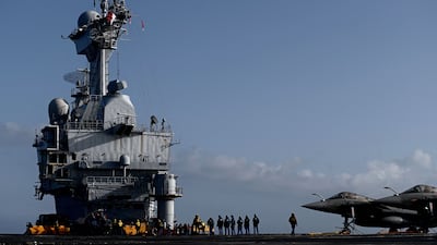 Military personnel and Rafale jet fighters on the deck of the French aircraft carrier Charles de Gaulle. AFP