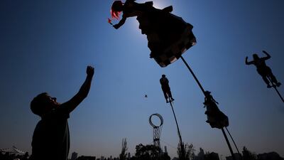A member of the Strange Fruit Circus Show troupe hands a flower to a fan during a performance before the start of the 2019 Australian Formula One Grand Prix at the Albert Park circuit in Melbourne. EPA