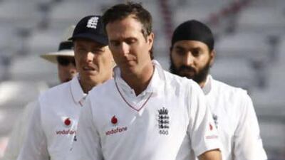The England captain Michael Vaughan leads his dejected team off the field.
