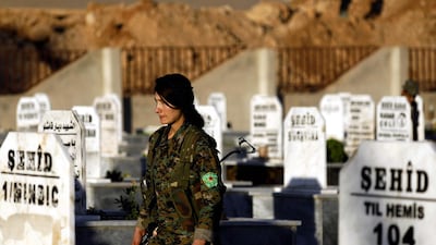 A fighter from the Syrian Democratic Forces attends the funeral of a commander. Delil Souleiman / AFP