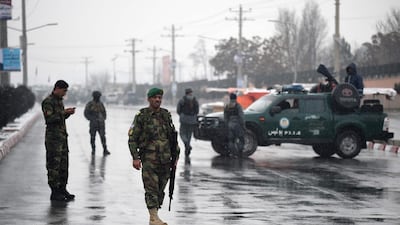 Afghan security personnel stand guard near the site of an attack near the Marshal Fahim military academy base in Kabul. Wakil Kohsar / AFP