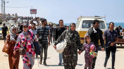 Displaced Palestinians take the coastal Rashid road to return to Gaza city as they pass through Nuseirat in the central Gaza Strip on Sunday. AFP