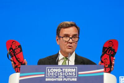 Greg Hands MP, Chairman of the Conservative Party holds up some flip-flops with the image of Labour leader Keir Starmer on them as he gives a speech on the first day of the Conservative Party Conference on October 1, in Manchester. Getty Images