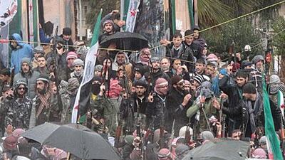 Syrian soldiers, who defected to join the Free Syrian Army, mingle with demonstrators during a protest against the regime in Idlib, Syria.