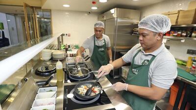 Chef Raymond, right, creates Cajun Fiesta pasta while Chef Edward creates a Vegan Mojo wrap at Sweet Greens. Chris Whiteoak / The National
