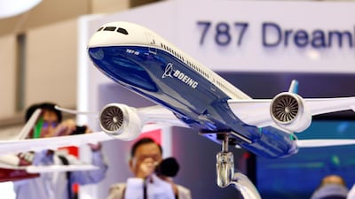 Visitors take pictures of a model of Boeing's 787 Dreamliner which has lower operating costs than other aircraft and made of composites. Reuters
