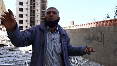 The Janitor of Hanadi tower Abu Mohammed Rqaiq points toward what remains of the building. Rakan Abed El Rahman for The National