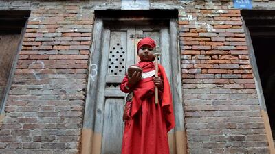 A Nepalese Buddhist boy attends Bratabandha, a coming-of-age ceremony, in Kathmandu on March 5, 2014. In Newari culture of the Shakya caste, the heads of young boys are shaved and they don a monk's robe for the ceremony practised in the hill communities of Nepal. Prakash Mathema / AFP photo