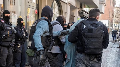A man is led away by police during a raid in Berlin. AP