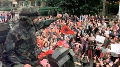 A British tank commander waves to townspeople in the centre of Podujevo, Albania in 1999 as Nato peacekeeping troops move in. Tim Ockenden / AFP