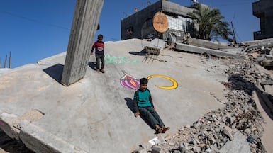Displaced Palestinian children play among the ruins of a building painted with a Ramadan decoration, in Khan Younis, southern Gaza. EPA