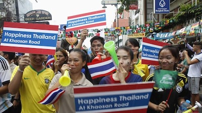 Workers hold placards during a celebration to boost tourism on Khaosan Road in Bangkok on June 13, 2014. Chaiwat Subprasom / Reuters