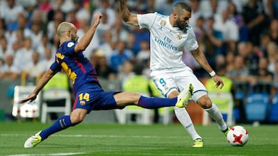 Real Madrid's Karim Benzema is challenged by Barcelona's Javier Mascherano. Francisco Seco / AP Photo
