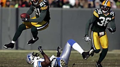 The Packers cornerback Charles Woodson (No 21) intercepts a pass during the Lions' defeat to Green Bay.
