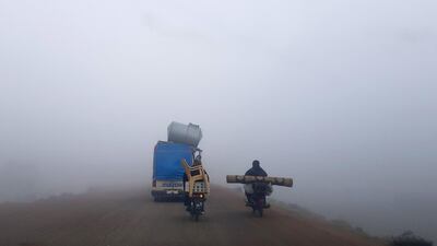 Motorcycles and vehicles loaded with furniture and other items drive along a highway near Sarmada in Syria's northwestern Idlib province, fleeing bombardment in the province's south on their way to areas near the Syrian-Turkish border. AFP