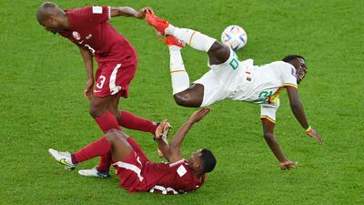 Bamba Dieng of Senegal, right, is challenged by Abdelkarim Hassan and Assim Madibo. Getty Images