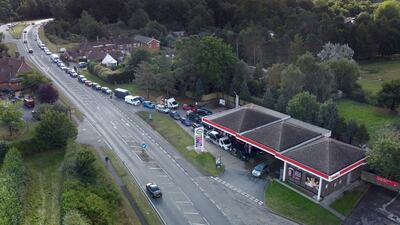 Motorists queue for fuel at a petrol station in Ashford, Kent, England on Wednesday. A government minister said the number of empty stations has halved since the weekend. AP