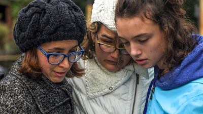People read from a religious text and embrace on the intersection of Shady Avenue and Northumberland Street after multiple people were killed at the Tree of Life Congregation synagogue. AP Photo