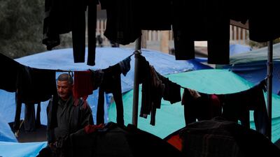 A man walks between tents and hanging laundry at a sports complex sheltering thousands of Central Americans. AP Photo