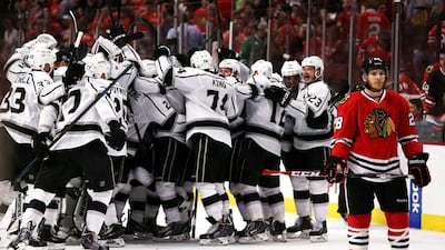 Ben Smith, right, of the Chicago Blackhawks skates away as the Los Angeles Kings celebrate after defeating the Blackhawks 5-4 in overtime in Game 7 to win the Western Conference final of the Stanley Cup play-offs on June 1, 2014, in Chicago, Illinois. Jonathan Daniel / AFP