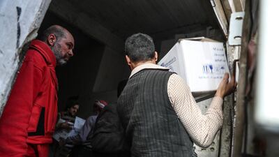 Volunteers with Syrian Arab Red Crescent (SARC) unload aid trucks in Douma, in Eastern Ghouta, Syria, on March 5, 2018. Mohammed Badra / EPA