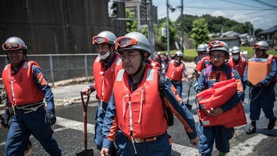 Emergency service workers arrive to search for people following a landslide in Yanohigashi. Getty Images