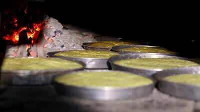 Dishes of rawani dessert are baked in a wood-fired oven during the holy month of Ramadan in Sanaa, Yemen April 16, 2021. Reuters